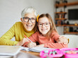 © Lumos sp - grandchild grandmother family granddaughter child teacher homework creativity home woman book notebook grandma education classroom grandparent parent daughter girl kid teaching