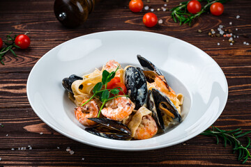 Canvas Print - Linguini pasta with mussels, shrimps, cherry tomatoes, sauce and herbs.