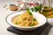 Spaghetti aglio e olio. Traditional Italian pasta with garlic, olive oil and chili peppers in plate on concrete background.