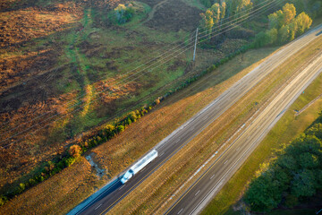 Wall Mural - Aerial view of busy american freeway with fast moving cars and trucks. Interstate hauling of goods concept