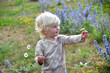 portrait of cute caucasian little boy holding daisy flower
