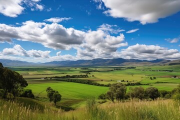 Sticker - rolling countryside with towering range of clouds and blue sky in the distance, created with generative ai