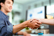 © Monster Ztudio - Young Asian business people shaking hands. Partners meeting in modern office
