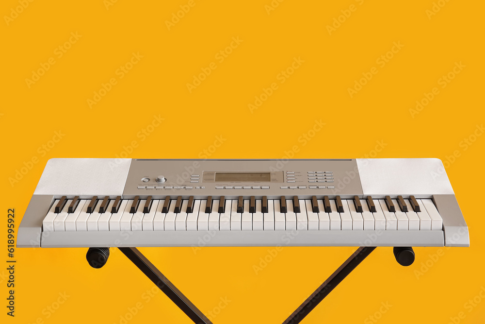 Modern synthesizer on yellow background