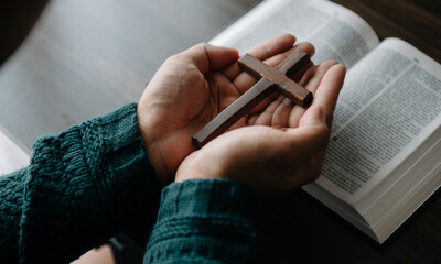 man praying on holy bible in the morning.Woman hand with Bible praying. Christian life crisis prayer to god. in sun light