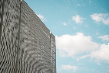 Poster - Modern gray architectural structure against a bright blue sky