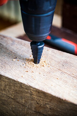 Wall Mural - Stepped conical drill on a wooden background close-up.