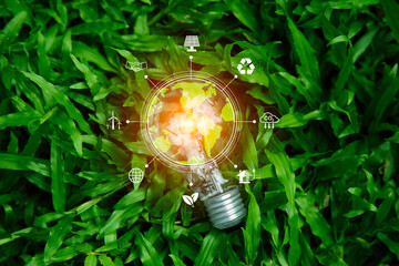 green energy concept help reduce global warming..hand holding natural background light bulb on green