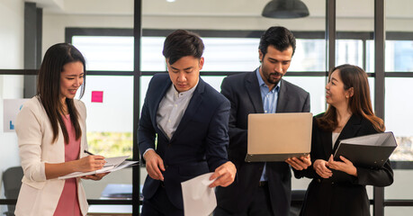 Wall Mural - Asian business man and woman meeting analyzing and discussing strategy with startup project.Creative business people plan and brainstorm with laptop computer on conference in office.Teamwork