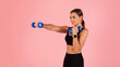 © Prostock-studio - Sporty woman doing exercises with dumbbells on pink studio background