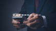 © nuruddean - Businessman using mobile smartphone for loading data application.