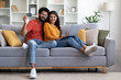© Prostock-studio - Young Indian Couple With Credit Card And Laptop Posing In Home Interior