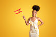 © Prostock-studio - Cheerful young african american woman in dress hold Spain flag, isolated on yellow studio background