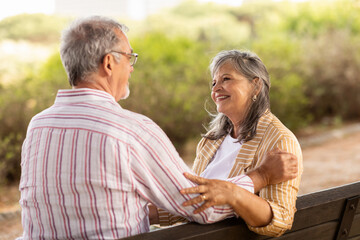 Wall Mural - Positive old european wife and husband enjoy rest, relax together, tender moment in park at spare time