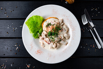 Sticker - Potato pancakes with chicken, bacon, lettuce, sauce and microgreens in a plate.