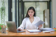 © Wasana - Young businesswoman working diligently, focus on working in front of the laptop. Analyze and plan new projects.