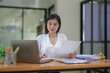 © Wasana - Young businesswoman working diligently, focus on working in front of the laptop. Analyze and plan new projects.