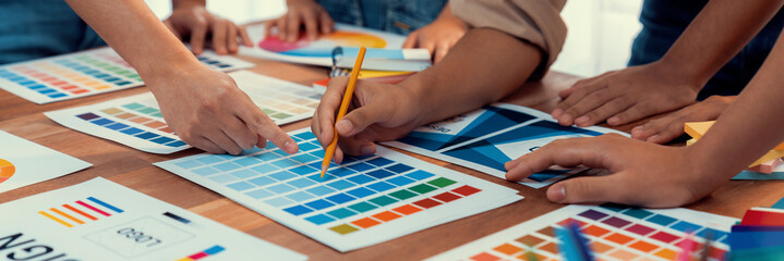 Poster - Graphic designer brainstorm logo and graphic art at busy creative studio workshop. Experiment and brainstorm color palette and pattern at workspace table for creative design. Panorama shot. Scrutinize
