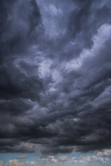 Wall Mural - Epic Dramatic storm dark grey cumulus rain clouds against blue sky background texture, thunderstorm