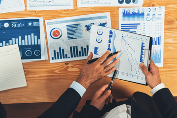 Poster - Top view analyst team discussing financial data on digital dashboard, analyzing chart and graph papers by data science software on wooden table background. Business intelligence and Fintech. Fervent