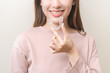 © KMPZZZ - Dental invisible braces, beautiful smiling asian young woman holding invisalign braces, wearing orthodontic silicone trainer, white smile using invisible whitening tray. Stomatology, dental healthcare