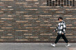 © Evgeny - young man walks down the street in front of a brick wall