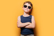 © ADDICTIVE STOCK - Stylish boy in sunglasses with crossed arms in studio