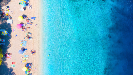 Wall Mural - aerial view on beach, pepole and umbrellas. vacation and adventure. beach and blue water. top view f