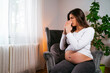 © phoenix021 - Pregnant young woman catches cold, sitting at home sick