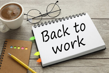 back to work text on the notebook with coffee on wooden table