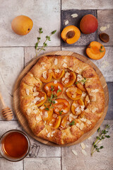 Wall Mural - Galette with apricots, brown sugar, honey, and almond petals. Delicious homemade open sweet pie tart with honey and seasonal fruits.