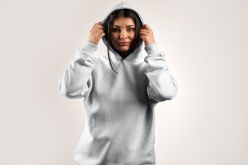 Wall Mural - Woman Showcasing a white Hoodie for Logo Branding. Streetwear clothing mock-up. Logo on shirt template copy space.