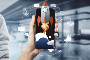Aufkleber - Female hand holding cellphone with creative rocket ship sketch on blurry office background. Content launch and spaceship concept.