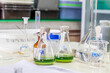 Laboratory glassware with green liquid in a science research laboratory.