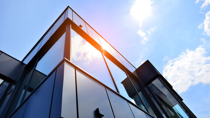 Graphite facade and large windows on a fragment of an office building against a blue sky. Modern aluminum cladding facade with windows.