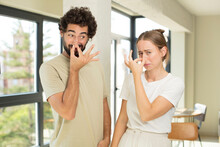 Young Adult Couple Feeling Disgusted, Holding Nose To Avoid Smelling A Foul And Unpleasant Stench