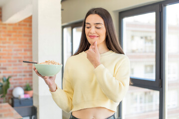 Wall Mural - pretty young model smiling with a happy, confident expression with hand on chin. breakfast bowl concept