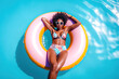 © Jim1786 - black happy woman in swimming pool floating on swimming ring, girl having fun on summer vacation in tropical hotel resort, tourism, top view, generative ai.