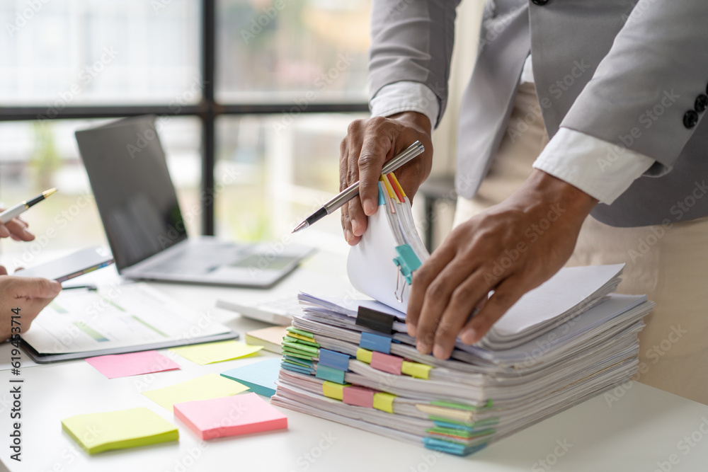 Businessman man working in stacks of papers searching for unfinished ...