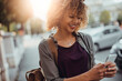 © Geber86 - Young woman using a smart phone while on a city street