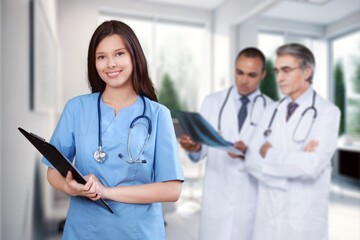 Wall Mural - Young female doctor portrait with medical team on background, AI generated image