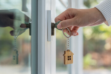 Wall Mural - Landlord key for unlocking house is plugged into the door. Second hand house for rent and sale. keychain is blowing in the wind. mortgage for new home, buy, sell, renovate, investment, owner, estate