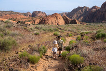 A Small Boy And A Girl Hiking In Snow Canyon, St. George, Utah, USA. Kids Walking In Red Rocks.