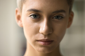 serious beautiful face of young teenage girl with short haircut, clean smooth skin looking at camera