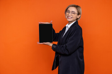 Wall Mural - Smiling joyful woman wearing black official style suit showing empty screen of tablet