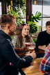 © bondvit - Group of happy relaxing friends drinking beer and coctails and having talk in pub restaurant. Celebration and party concept