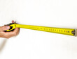 © valiantsin - Hand holding measuring tool for apartment wall measurement