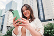 © Jose Calsina - Joyful young lady using a mobile phone to do online shopping or having video call. Entrepreneur woman having fun with her cellphone watching the social media, sending messages or browsing on internet