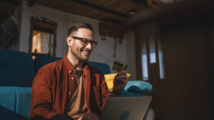One man caucasian male online shopping use laptop and hold credit card