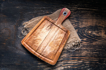 Wall Mural - Empty cutting board and burlap on a dark wooden table. View from above. copyspace.